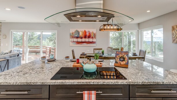 Una cocina moderna con encimera de granito, electrodomésticos de acero inoxidable y una isla de vidrio.