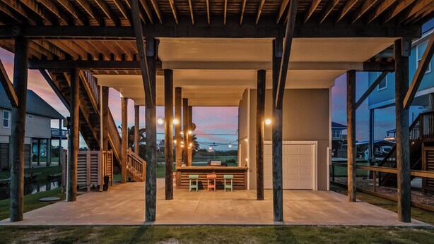 A covered outdoor area with a concrete floor, wooden beams, and string lights. - The Sea Turtle, Family and Dog Friendly, Cargo Lift, Crystal Beach TX Ocean View (Bolivar Peninsula/Crystal Beach)