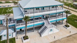 A multi-story building with a blue and white color scheme, featuring a bar and grill on the ground floor. - The Sea Turtle, Family and Dog Friendly, Cargo Lift, Crystal Beach TX Ocean View (Bolivar Peninsula/Crystal Beach)