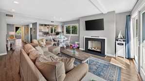 A modern living room with a sofa, coffee table, and fireplace. - PRIME Resort Location! Beachside, Ocean View, Pool Access! (Isle Of Palms)