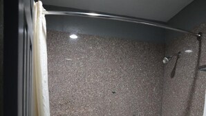 Een moderne badkamer met een bad, douche en toilet.