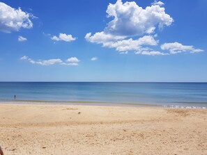 A beach with a clear sky and calm sea.