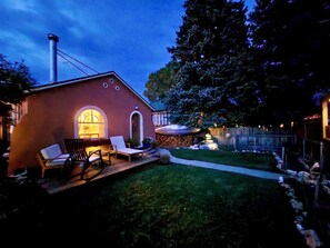 A house with a patio area, outdoor seating, and a well-maintained lawn.