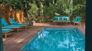 Una piscina al aire libre, sillones reclinables de piscina