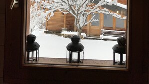 A window with a view of a snow-covered tree and a wooden building. - Nice Chalet LEON located in Plangagnant (1650 m) La PLAGNE - LA ROCHE chairlift (Plangagnant)