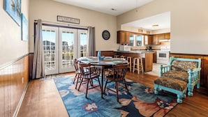 A dining room with a round table and chairs, a kitchen in the background, and a sign reading 'TO THE BEACH'. - High Tide - A Fisherman's Delight:  4 BR Channel Home w/ Boat Ramp in Cherry Grove (North Myrtle Beach)