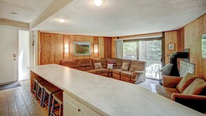 A cozy living area with a wooden interior, a large sofa, a coffee table, and a bar area with stools. - New Listing! Strike Gold at this Prime Location - Bus Route-Fast WiFi (Breckenridge)