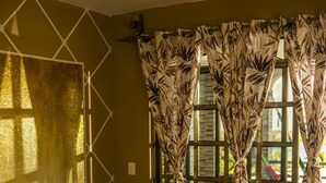 A bedroom with a bed, curtains, and a window.