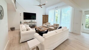 A spacious living room with a large sofa, a coffee table, and a television. - SEA PINES, 3RD ROW BEACH HOUSE, GREAT LOCATION, NEWLY RENOVATED MAIN AREA (Hilton Head Island)