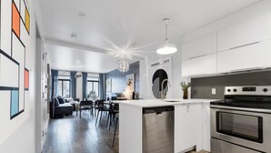 Eine moderne Küche mit Geschirrspüler, Backofen und einer Pendelleuchte.