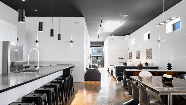 A modern kitchen with a long island, bar stools, and pendant lighting. - LiV MTL Plaza Grand Luxe Penthouse Near Downtown Montreal (Montréal)