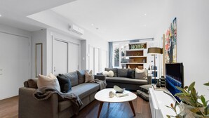 Ein modernes Wohnzimmer mit einer Couch, einem Couchtisch und einem Bücherregal.