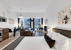 Een moderne hotelkamer met een groot bed, een bureau, een zithoek en een eethoek.
