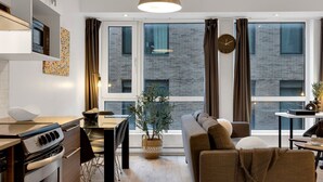 En moderne opholdsstue med et køkken, spiseplads og siddeområde.