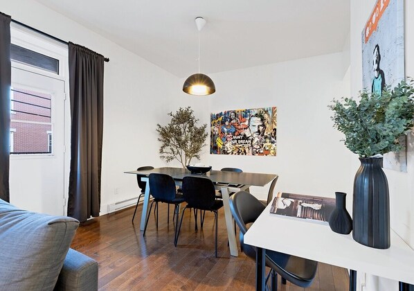 Un área de comedor moderna con una mesa, sillas y una lámpara colgante.