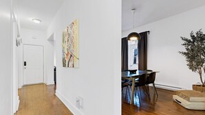 A hallway with a door, a dining area with a table and chairs, and a plant. - Spacious 4BR rooftop near Downtown (Montréal)
