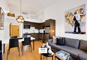 Un appartement moderne comprenant un coin repas, une cuisine et un salon.