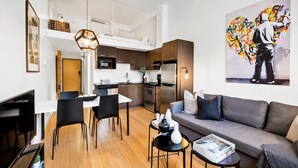 A modern apartment with a dining area, kitchen, and living room. - LiV MTL Main Plateau Urban Suites Near Downtown Montreal (Montréal)