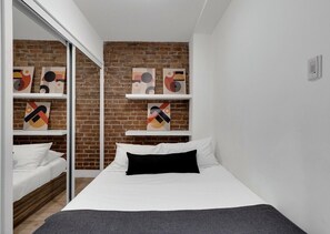 2 habitaciones, escritorio y tabla de planchar con plancha
