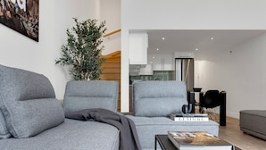 Un salon moderne avec un canapé gris, une table basse et une bibliothèque.