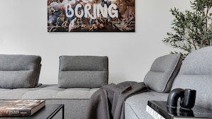 Un salon moderne avec un canapé gris, une table basse et un livre.
