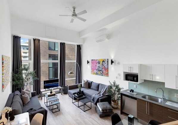 A modern apartment with a living room, kitchen, and dining area.