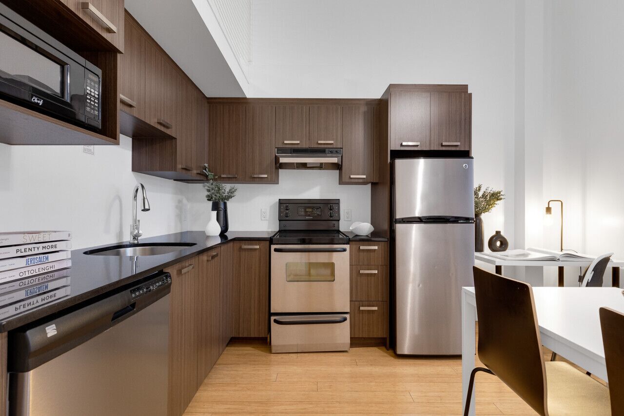 A modern kitchen with wooden cabinets, stainless steel appliances, and a dishwasher.