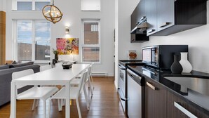 Eine moderne Küche mit dunklen Schränken, einer weißen Arbeitsplatte und einem eingebauten Backofen.