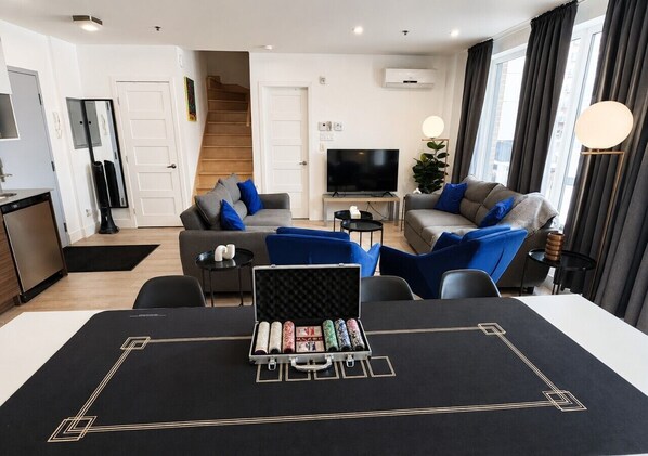 A modern living room with a sofa, a television, and a coffee table.