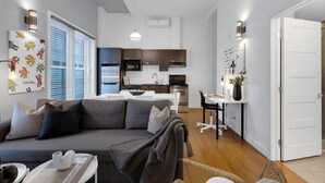 A modern apartment with a living room, dining area, and kitchen.