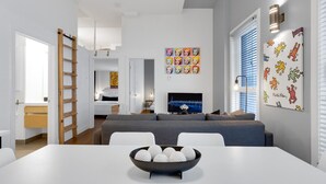 A modern living room with a grey sofa, a TV, and artwork on the wall.