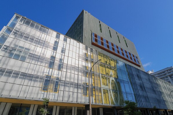 A modern building with a glass facade and a prominent sign.