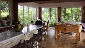 Un comedor con una mesa larga, sillas y una mesa de fútbol de mesa.