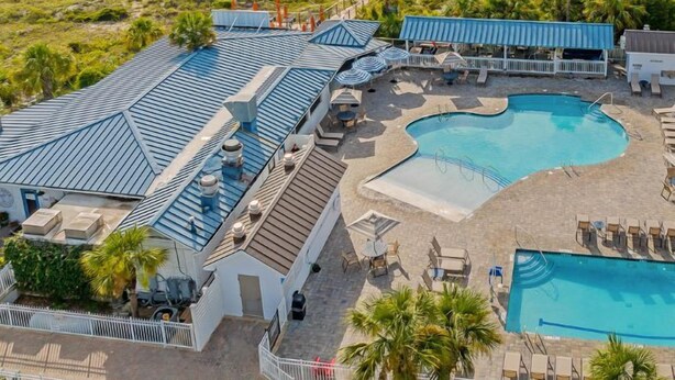 A resort with a large pool area, multiple lounge chairs, and a view of the beach and ocean. - Summer & July 4th Savings at Beachside Colony Tybee's ONLY Oceanfront Resort 1/1 (tybee island)