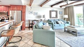 A spacious living area with a kitchen, a dining table, and a sofa. - Summer & July 4th Savings at Beachside Colony Tybee's ONLY Oceanfront Resort 1/1 (tybee island)
