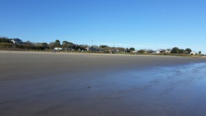 Une vaste plage de sable fin, sous un ciel dégagé.