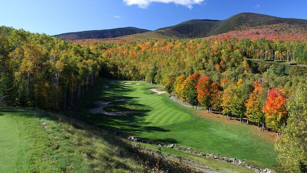 A golf course with a clear path, surrounded by autumn-colored trees and hills in the background. - Sugarloaf Mt. - on the mountain, indoor pool, short walk to lift, quiet (Carrabassett Valley)