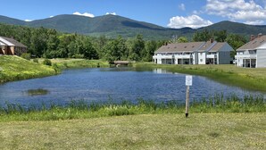A lakeside property with a house, a dock, and a sign indicating fishing and boating activities. - Sugarloaf Mt. - on the mountain, indoor pool, short walk to lift, quiet (Carrabassett Valley)