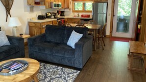 A compact living space with a sofa, coffee table, and dining area. - Sugarloaf Mt. - on the mountain, indoor pool, short walk to lift, quiet (Carrabassett Valley)