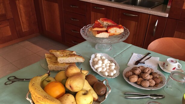 Uma mesa com diversos alimentos, incluindo pão, frutas e nozes.