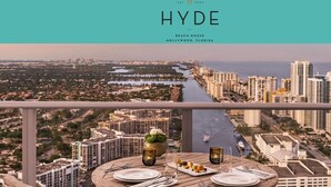 A table set for dining with a view of a cityscape and water.