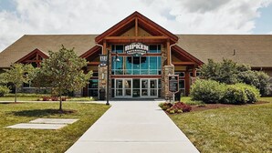 A hotel with a prominent sign reading "RIPKEN EXPERTISE" and a large entrance with glass doors. - Heavenly View – Romantic Pigeon Forge Cabin with Hot Tub, Jacuzzi & Pool Table (Sevierville)
