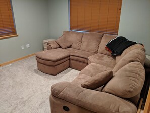 A sectional sofa in a room with light green walls and wooden blinds. - Quiet Guest House close to Pinedale with Mountain View (Pinedale)
