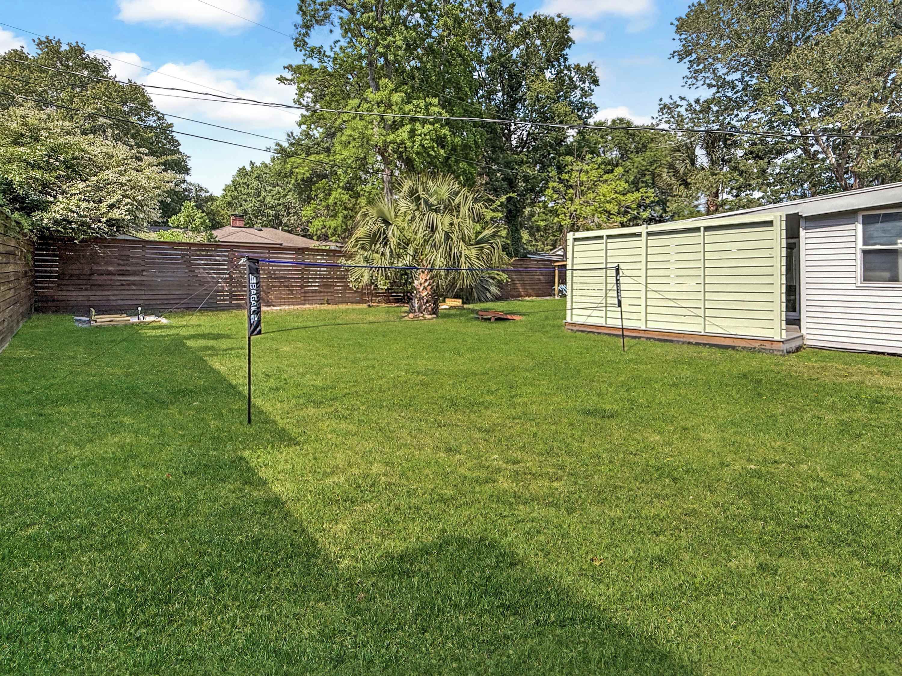 A backyard with a flag, a wooden fence, and a house.