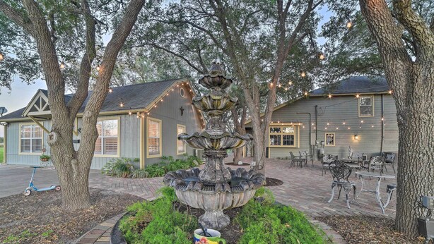 Une fontaine entourée d’arbres et un espace patio avec des sièges extérieurs.