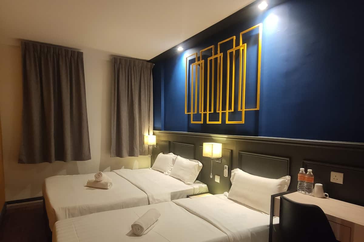 A hotel room with two beds, a desk, and a chair.