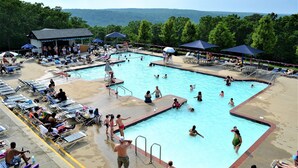 A swimming pool with multiple lanes, sun loungers, and umbrellas. - Cozy Creekfront House with Sauna (Bushkill)