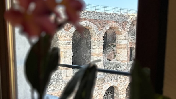 A view of a stone building with arched windows and a metal fence in the background. - Arena Deluxe - Duplex apartment with Arena view (Verona)