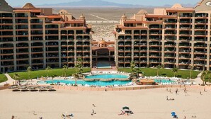 Un complexe hôtelier comprenant des bâtiments à plusieurs étages, une piscine centrale et une zone de plage.
