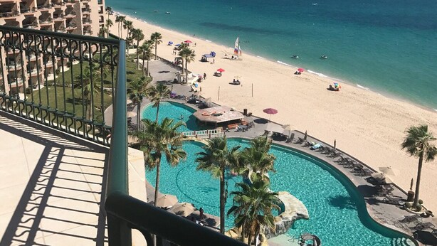 Un complexe hôtelier doté d’une piscine, d’une plage et offrant une vue sur l’océan.